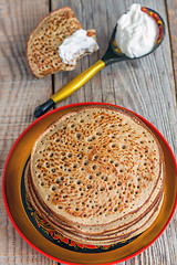 Image showing Whole grain pancakes and a spoon of sour cream.