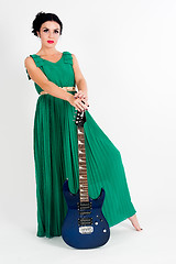 Image showing Pretty woman in long green dress with guitar