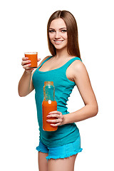 Image showing Happy teen girl holding a glass of carrot juice