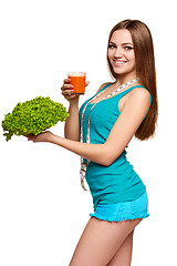 Image showing Happy teen girl holding a glass of carrot juice