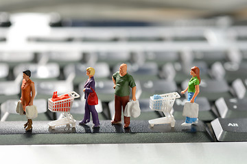 Image showing Miniature shoppers  with shopping cart