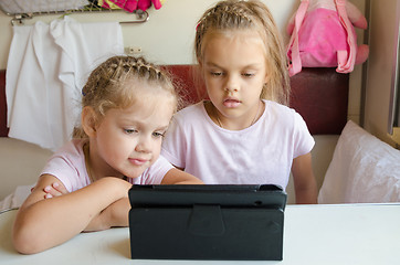 Image showing Two girls looking at the tablet in the train