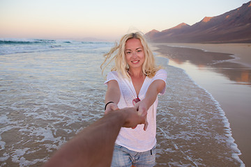 Image showing Romantic couple, holding hands, having fun on beach.