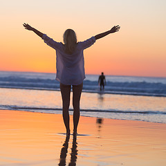 Image showing Free woman enjoying vacations on beach at sunset.