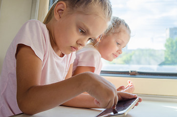 Image showing Girl playing in a mobile phone in a train