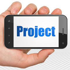 Image showing Finance concept: Hand Holding Smartphone with Project on display