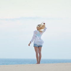 Image showing Woman on sandy beach in morning. 