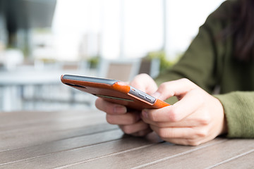 Image showing Woman texting on her mobile phone at outdoor cafe