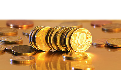 Image showing Stack of coins close-up on a gold background
