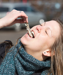 Image showing Dutch woman is eating typical raw herring
