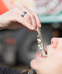 Image showing Dutch woman is eating typical raw herring