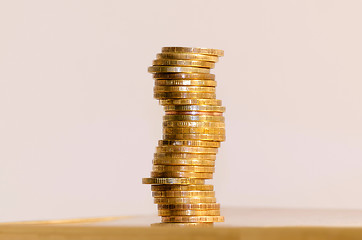 Image showing Stack of coins close-up on a gold background