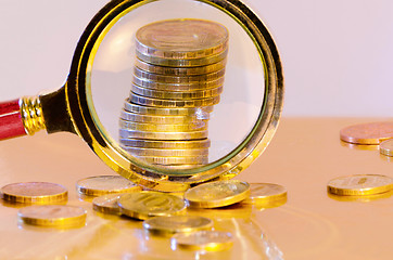 Image showing A stack of coins under a magnifying glass