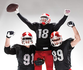 Image showing The three american football players posing on white background