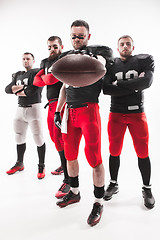 Image showing The four american football players posing with ball on white background