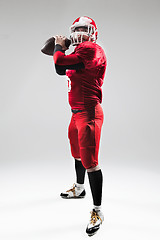 Image showing American football player posing with ball on white background