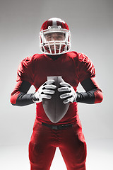 Image showing American football player posing with ball on white background