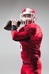 Image showing American football player posing with ball on white background