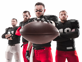 Image showing The four american football players posing with ball on white background