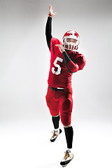 Image showing American football player posing with ball on white background