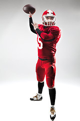 Image showing American football player posing with ball on white background