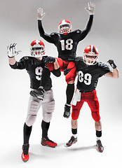 Image showing The three american football players posing on white background