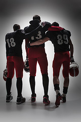 Image showing The three american football players on gray background