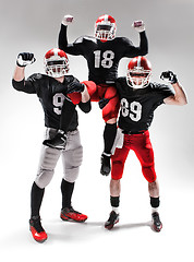 Image showing The three american football players posing on white background