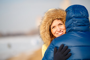 Image showing happy pair of male and female embracing ain winter outdoors