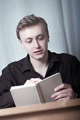 Image showing Young man reading a book