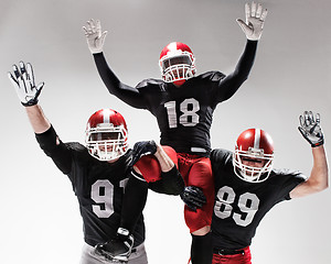 Image showing The three american football players posing on white background