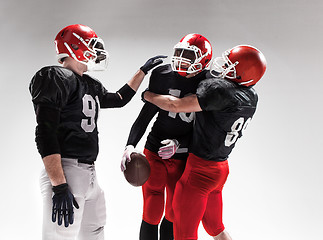 Image showing The three american football players posing on white background