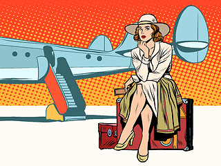 Image showing Tourist girl sitting on a suitcase, travelling by plane