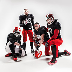 Image showing The four american football players posing with ball on white background