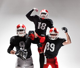 Image showing The three american football players posing on white background