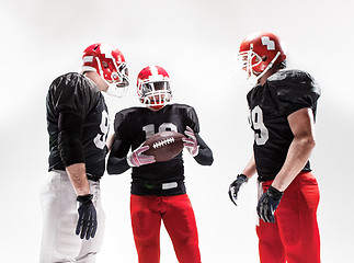 Image showing The three american football players posing with ball on white background