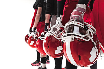 Image showing The hands of american football players with helmets on white background