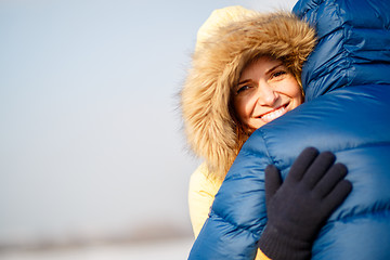 Image showing happy pair of male and female embracing ain winter outdoors