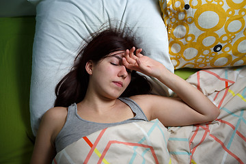 Image showing Tired woman sleeping on a bed at home