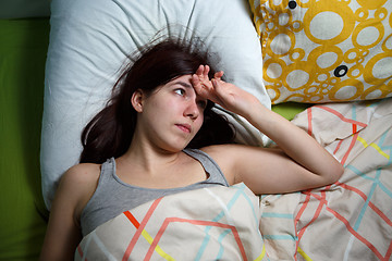 Image showing Tired woman sleeping on a bed at home