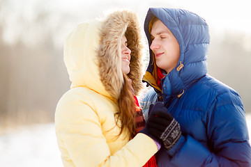 Image showing happy pair of male and female embracing ain winter outdoors