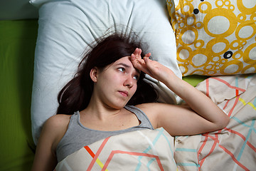 Image showing Tired woman sleeping on a bed at home
