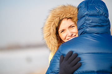 Image showing happy pair of male and female embracing ain winter outdoors