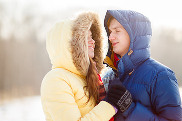 Image showing happy pair of male and female embracing ain winter outdoors