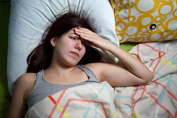 Image showing Tired woman sleeping on a bed at home