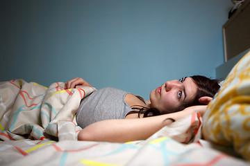 Image showing Young woman lying in bed suffering with insomnia  Noisy neighbour, stress, alarm sound, prevent from sleep concept