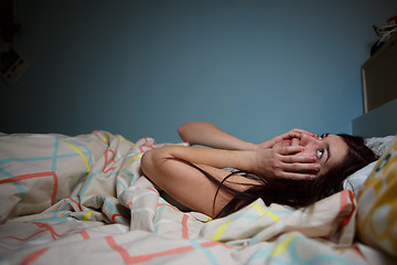 Image showing Young woman lying in bed suffering with insomnia  Noisy neighbour, stress, alarm sound, prevent from sleep concept