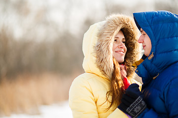 Image showing happy pair of male and female embracing ain winter outdoors