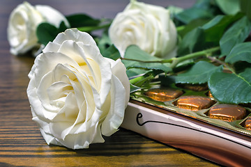 Image showing White roses and chocolates as a gift.