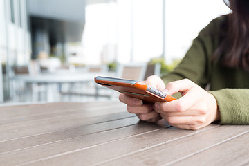 Image showing Woman using cellphone at outdoor cafe